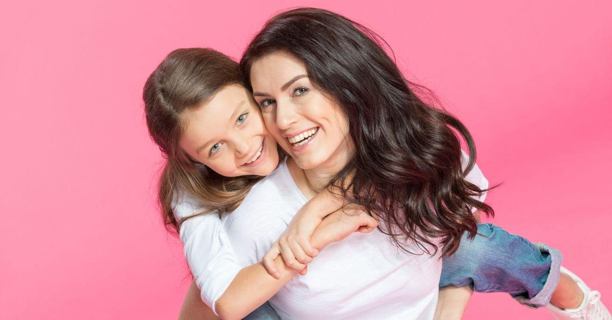 mom gives daughter a piggyback ride after being sick with braces